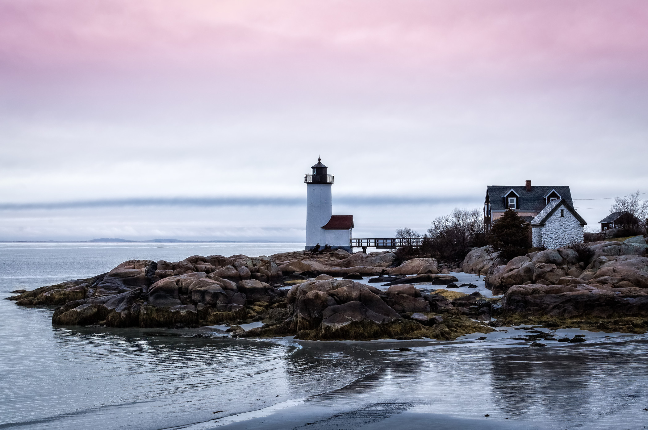 A lighthouse standing tall on a peninsula in New England